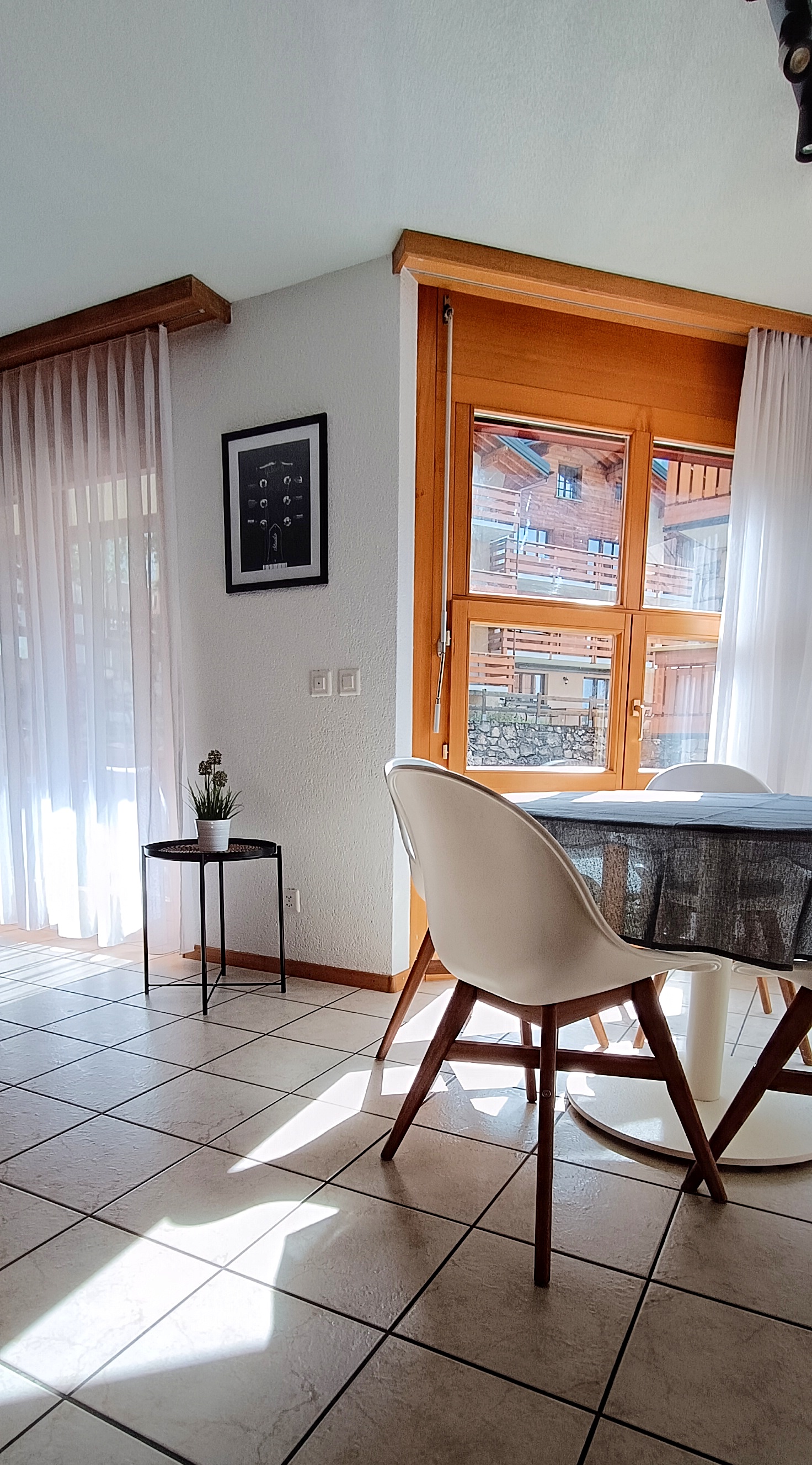 Zona pranzo dell'appartamento Altrove a Leukerbad, con vista sulle montagne e lavagna informativa