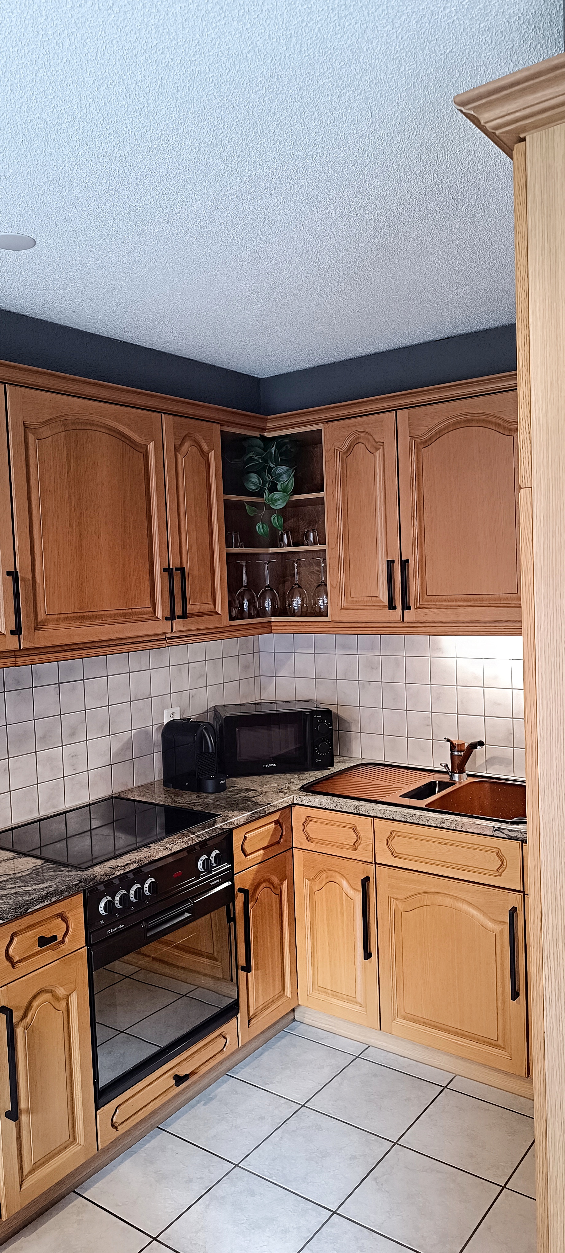 Cucina angolare in legno attrezzata con fornelli, microonde e macchina da caffè