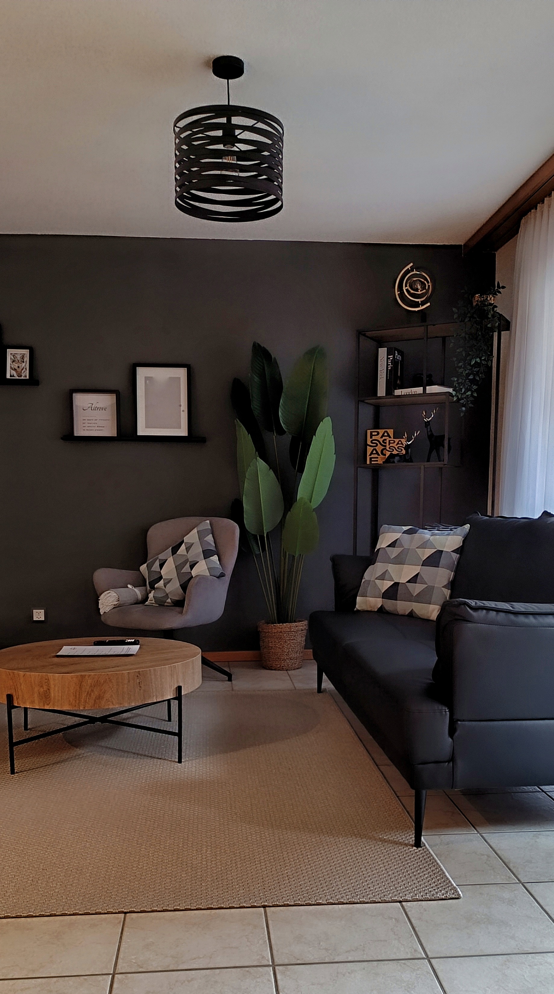 Zona giorno moderna con TV a schermo piatto, parete decorativa e poltrona relax